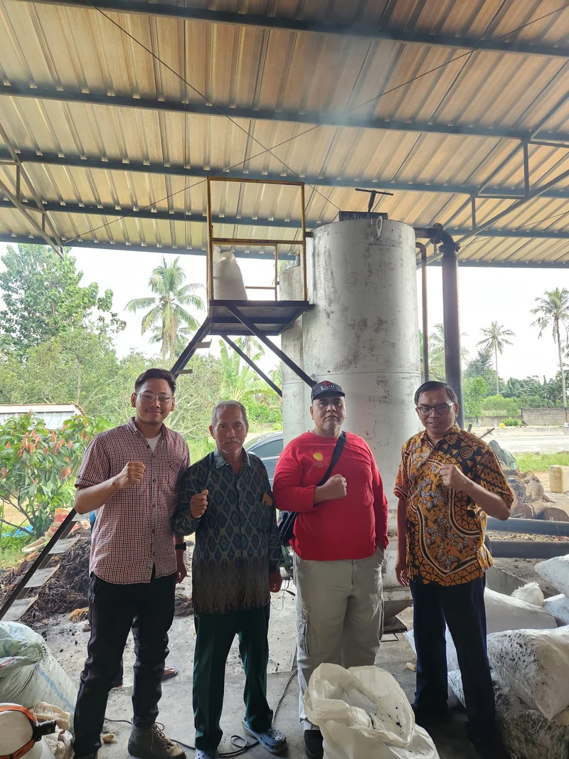 Four project team members at the biomass processing site
